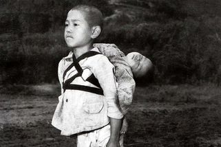 Fotografie chlapce, který nese svého mrtvého bratra na zádech ke kremaci, dojímá k slzám - Médium.cz
