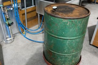 Pískovou baterii si vyrobil za pár korun ze starého sudu. Nabíjí se kamny na dřevo a vytápí skleník