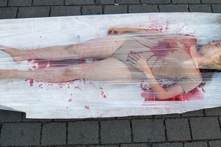 Nedívej se jinam. Lidé polití umělou krví protestovali v Praze proti vykořisťování zvířat - Novinky