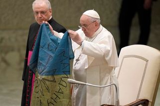 Papež políbil ukrajinskou vlajku, kterou mu přinesli z Buči