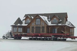 V Kanadě převezli kamionem obří srub, za ním jela i garáž