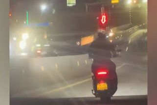 Pohled jako z videohry. Motorkář si nad helmu umístil svítící šipku