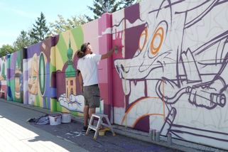 Prázdná zeď na Ruzyni se mění ve street art galerii. Na muralu pracuje 30 umělců - Novinky
